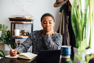Woman At Home Writes in Notebook