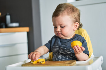 Toddler trying lemon for the first time.