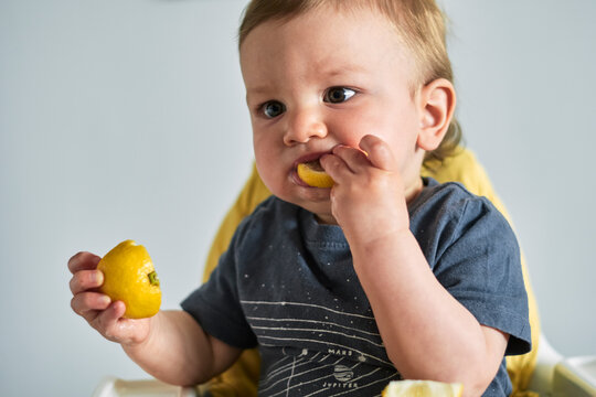 Toddler trying lemon for the first time.