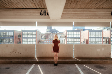Blond lady standing on empty city parking