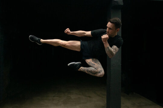 Kickboxer flying near pillar in gym