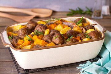 Meatballs with pumpkin, potatoes  and herbs in baking dish