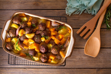 Meatballs with pumpkin, potatoes  and herbs in baking dish. Flat lay, layout, overhead