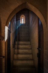 Loophole on an ancient castle, beautiful scene of stair with a ray of light