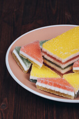 Colorful jelly candy in the plate on wooden background. Multi-colored marmalade jelly candy's. Heap of triangular and rectangular  marmalade candy.