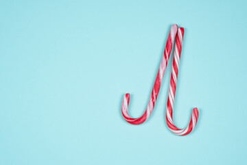 Two candy canes on a light blue background