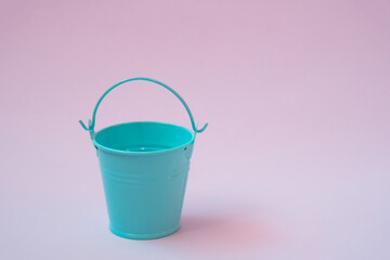 Blue bucket close-up on a pink background, minimalism