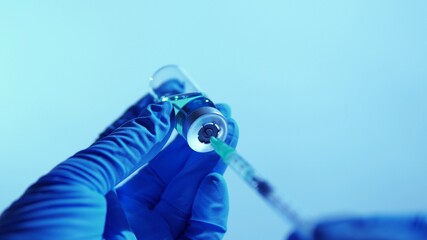 Hand of scientists in blue gloves holding vial with safe and effective vaccine against virus....