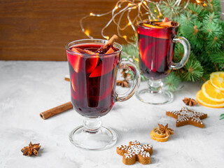 Christmas mulled red wine with spices and oranges on a wooden rustic table.New Year traditional drinks