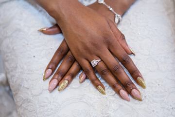 African young bride's elegant hands, new beautiful golden diamond engagement ring, long oval nails,...
