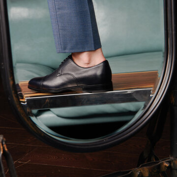 Reflection of a male foot in a leather boot.