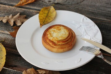 Delicious bun with cottage cheese on a wooden table