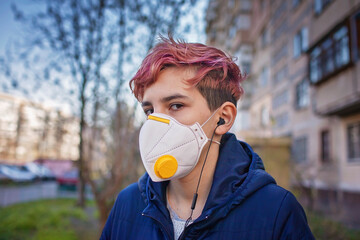 Stylish millennial girl wearing medical respirator listening music with earphone, gen Z