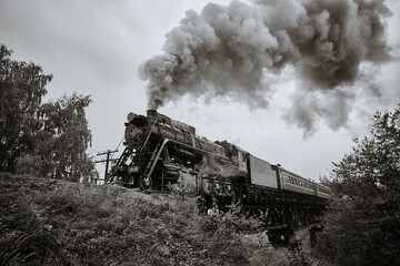 Fototapeta na wymiar The old locomotive produces a pillar of steam
