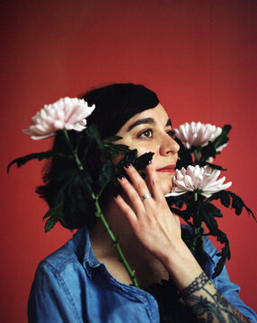 Girl With Flowers On Red Background