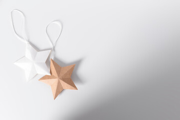 Fondo blanco con estrellas hechas de papel en colores blanco y kraft para navidad.