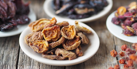 Dried apricots on the foreground.Background with bowls with various dried fruits on a wooden ancient background. Home preparation of dried fruits.