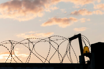 Prison fence made of barbed metal wire.
