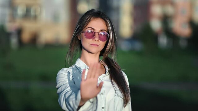 Portrait of confident trendy female shaking hand gesture no. Medium close up shot on 4k RED camera