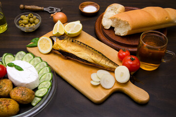 still life delicious food smoked fish with lemon and vegetables on the table
