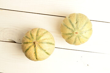 fragrant organic melons, close-up, on a white wooden table.