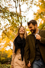 Naklejka na ściany i meble Young couple walking in the autumn park