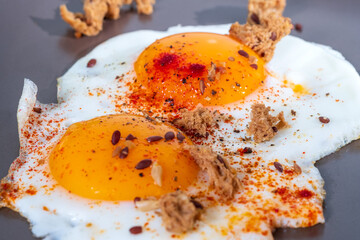 Two freshly fried eggs in frying pan, beautiful egg yolk, mouthwatering food