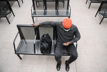 Black Man Wearing Face Mask Using Cellphone In The Station