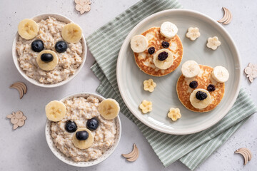 Kids breakfast oatmeal porridge and pancakes with funny bear face