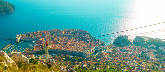 Wide panorama view of the Dubrovnik city, old town and the surrounding area seen from above from the Srd mountain, cablecar wire going towards the city