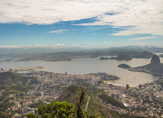 Rio de Janeiro, Brazil - December 24, 2008: Aerial view of bay from entrance to port and beyond. Tall buildings in many neighorhoods under blue cloudscape and mountains in distance.