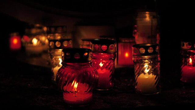 Commemorative candles burn in the dark