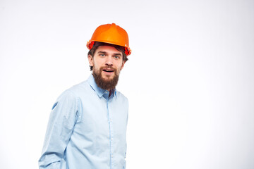 Man in orange hard hat industry engineer work professional light background