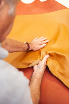 A worker testing and stretching leather in a shoe factory