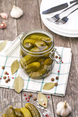 Pickled cucumbers with herbs and spices, on a wooden background, top view.