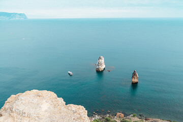 A beautiful view from the cliff to the water surface, where there are rocky shores.