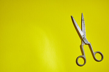 old scissors on a yellow background
