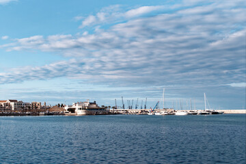 Fototapeta na wymiar A morning walk on the seafront in the city of Bari, in southern Italy. Panoramic view of the city pier on the cloudy sky background.
