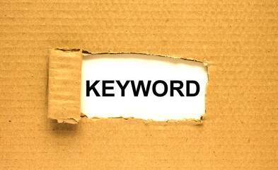 The word Keyword appearing behind torn brown paper