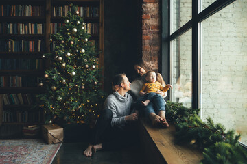 Happy family at home in cozy living room with a decorated festive Christmas tree