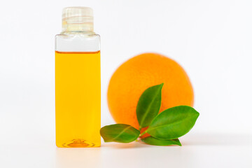 Orange oil for the body. Orange on a white background. Organic SPA cosmetics with herbal ingredients.