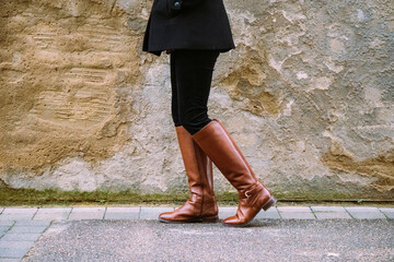 woman in boots walking on the street - wide