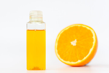 Orange oil for the body. Cut orange on a white background. Organic SPA cosmetics with herbal ingredients.