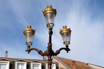 Fototapeta na wymiar Ville de Saint-Avold, candélabre à 3 branches ou réverbère rétro en centre ville, département de Moselle, France