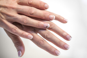 dos manos superpuestas con uñas decoradas sen un fondo blanco.