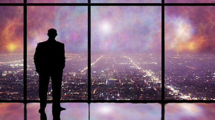 Silhouette of a man in the window looking at city skyline at night