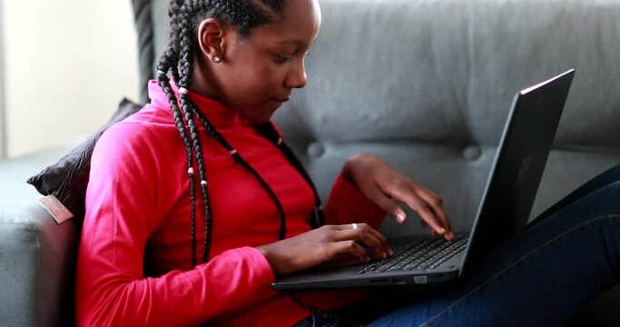 Child girl using laptop at home couch