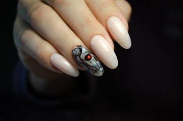 A woman's hand on a black background with a manicure and design for Halloween.