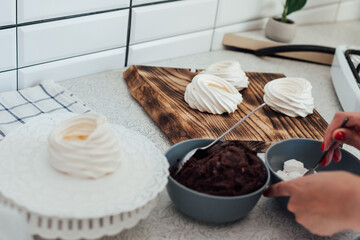 Beautiful woman pastry chef makes sweet cakes in kitchen