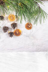 Christmas background with pine tree branches decorated with dried oranges, cone pine and lights